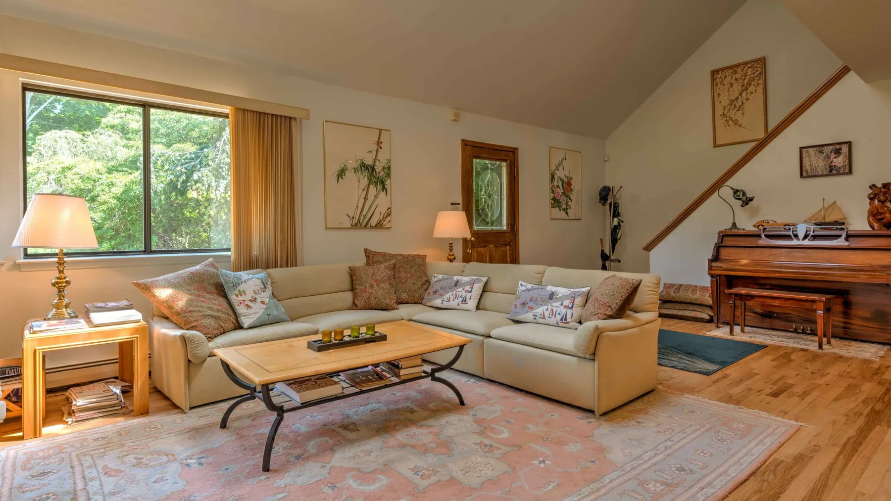 A living room with an L-shaped seating area, coffee table, and large window.