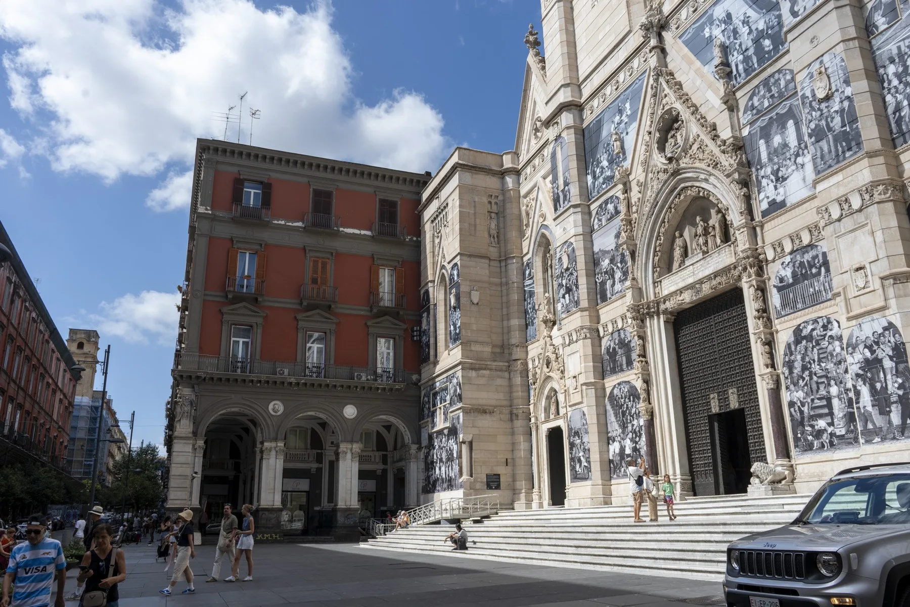 La fachada de piedra de una iglesia histórica, con amplios escalones, da a una plaza urbana.