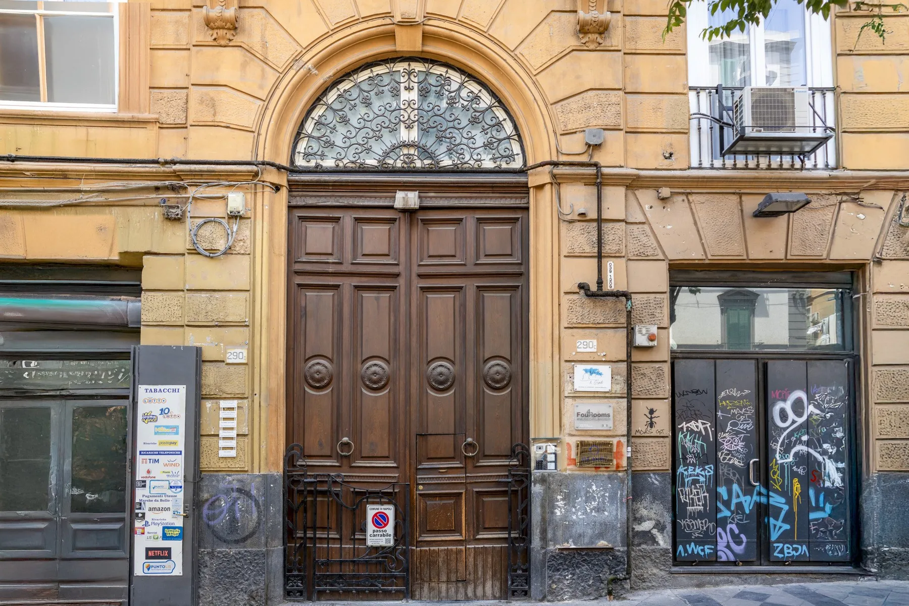Una puerta de entrada de madera ornamentada con una ventana arqueada de vidrio decorativo encima.