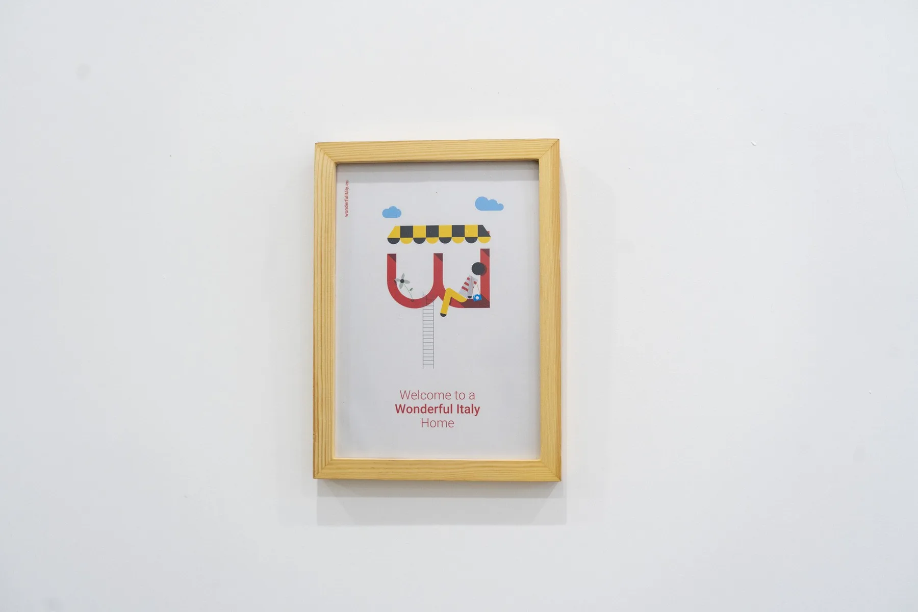 Una ilustración colorida enmarcada cuelga de una pared blanca lisa.