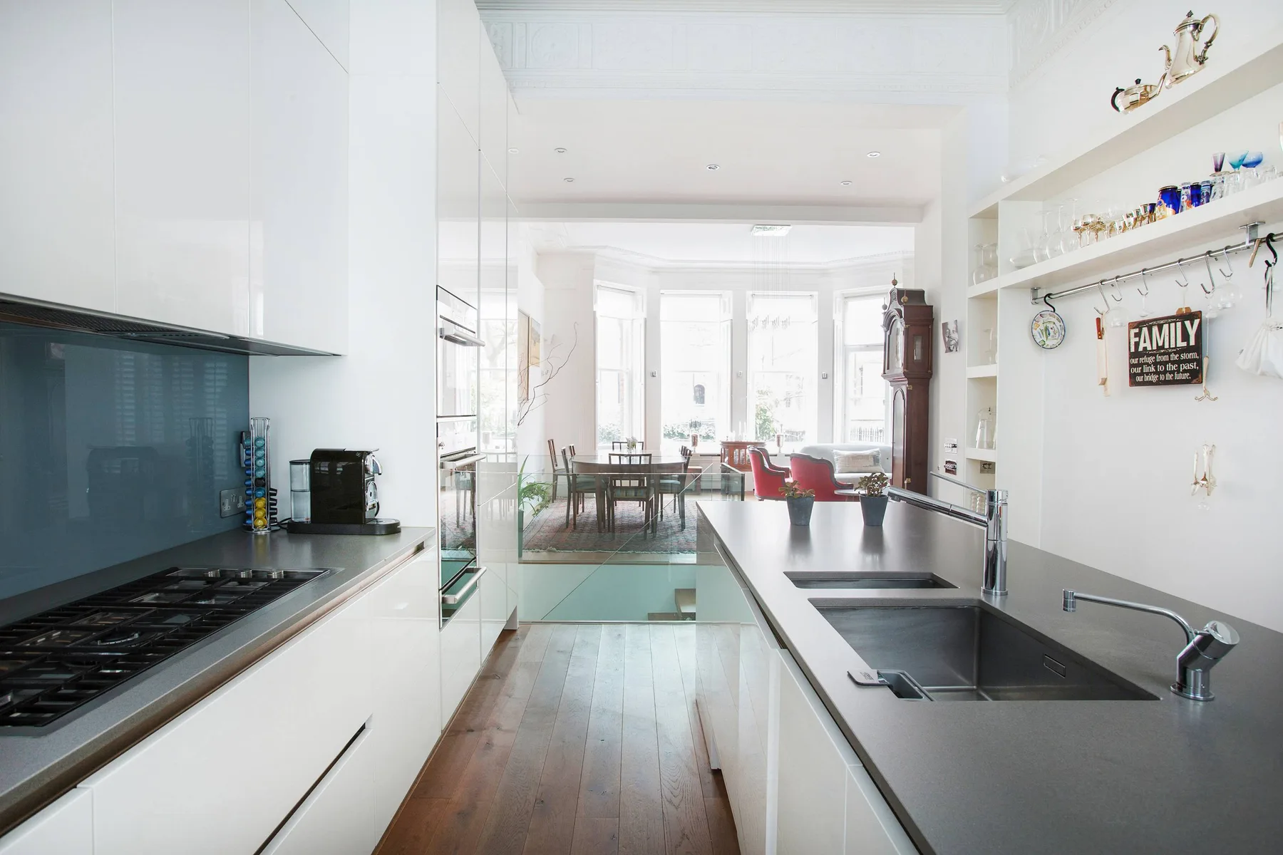 Una cocina luminosa se abre a un comedor con ventanales.