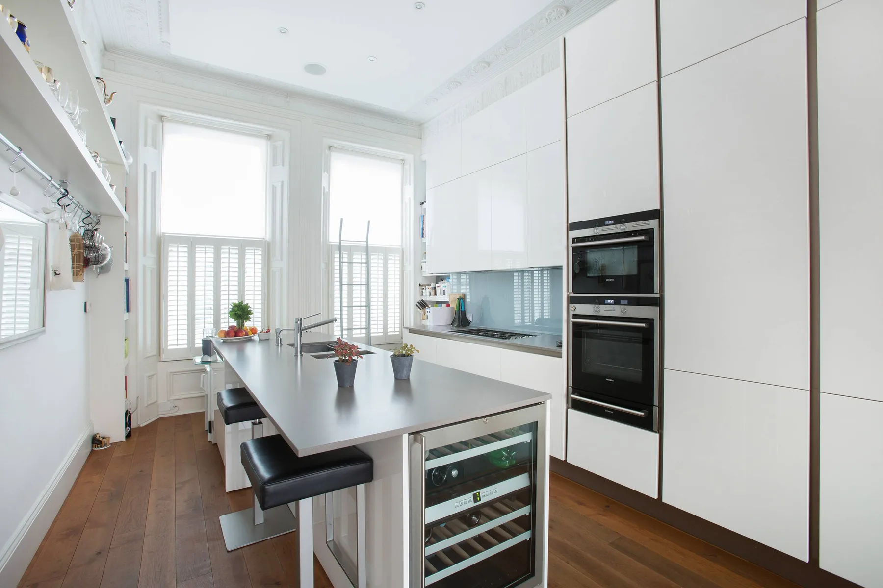 Una cocina moderna y luminosa con una isla central y electrodomésticos empotrados.