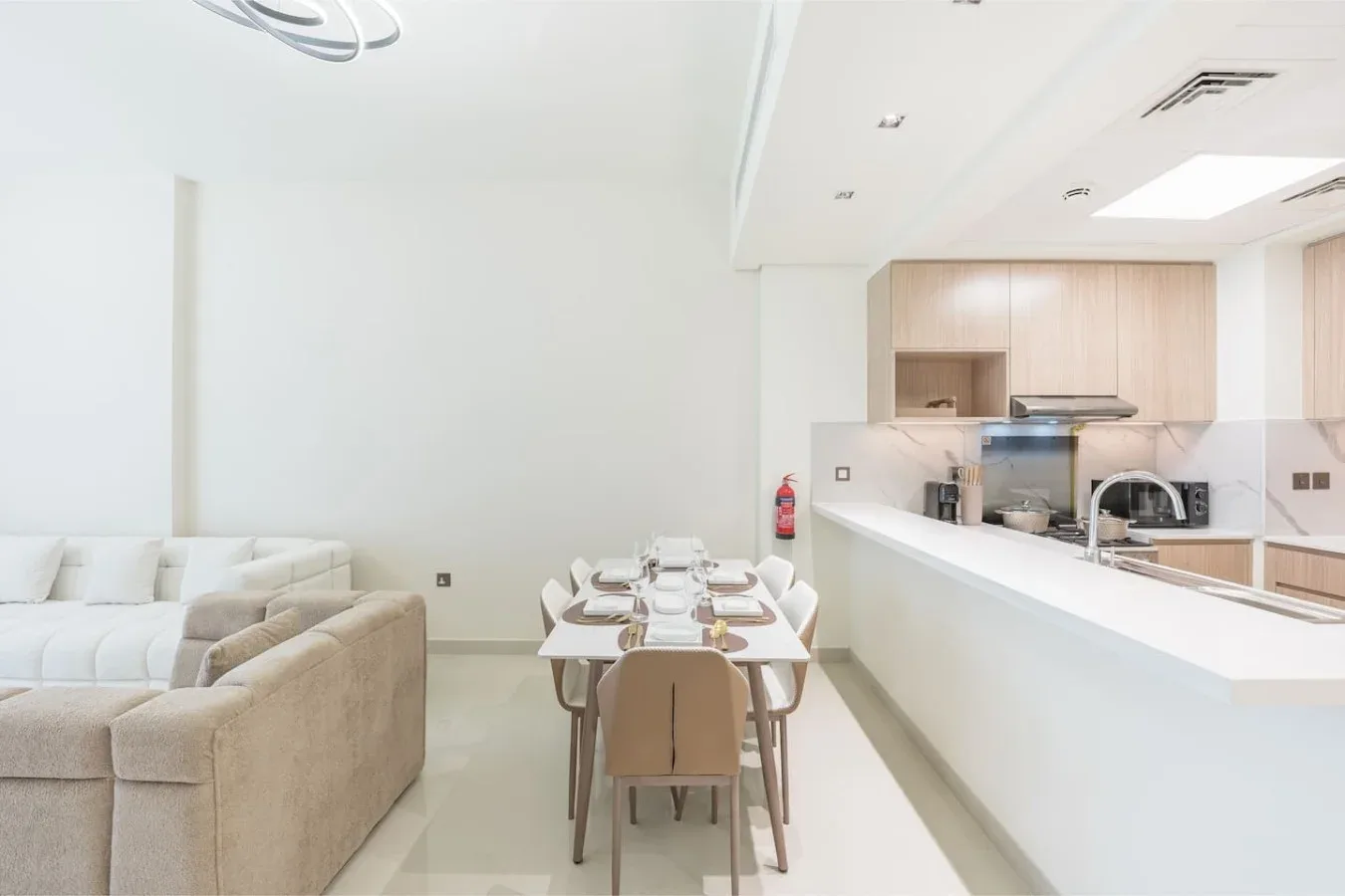 Una luminosa sala-comedor de concepto abierto con una cocina detrás de la barra.