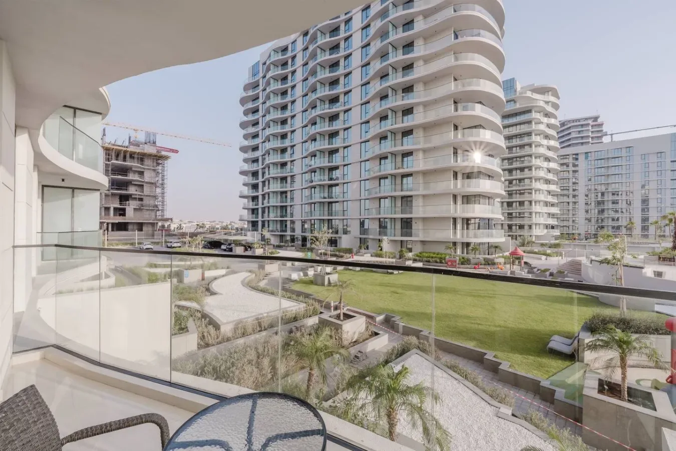 Un balcón da a jardines y edificios de apartamentos modernos.