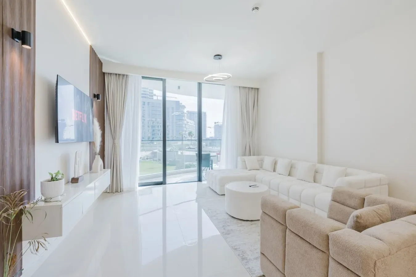 Una luminosa sala de estar con asientos y grandes ventanales con vistas a la ciudad.