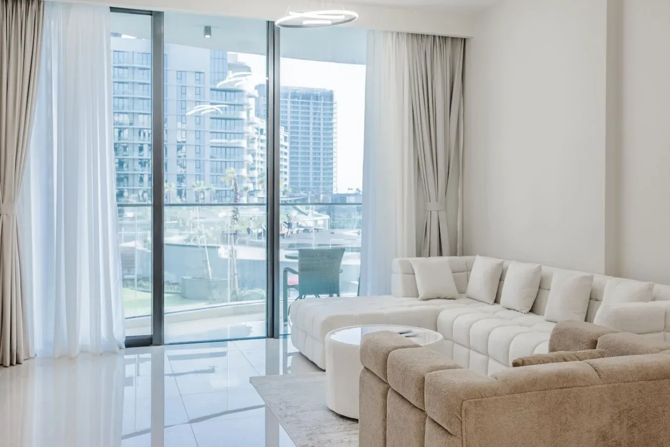 Una sala luminosa con asientos seccionales junto a ventanas de piso a techo.