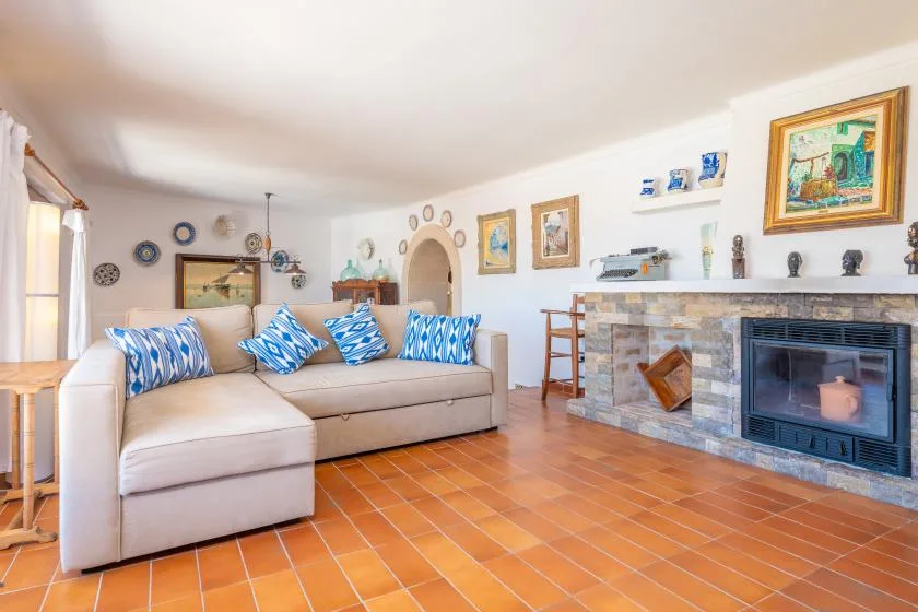 Una sala de estar con una zona de asientos y una chimenea de piedra.