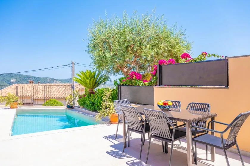 Una zona de comedor al aire libre con asientos junto a una piscina.