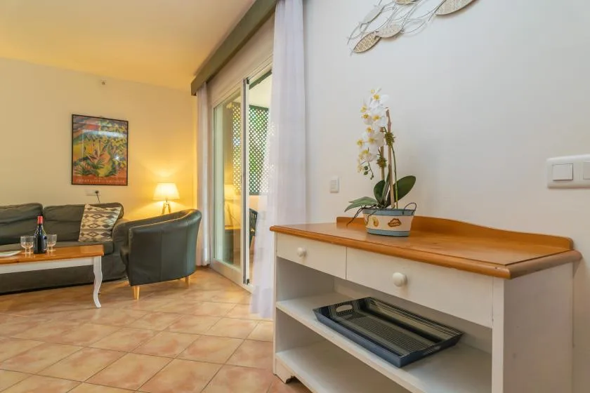 A living room with seating beside a sliding glass door and a console table.