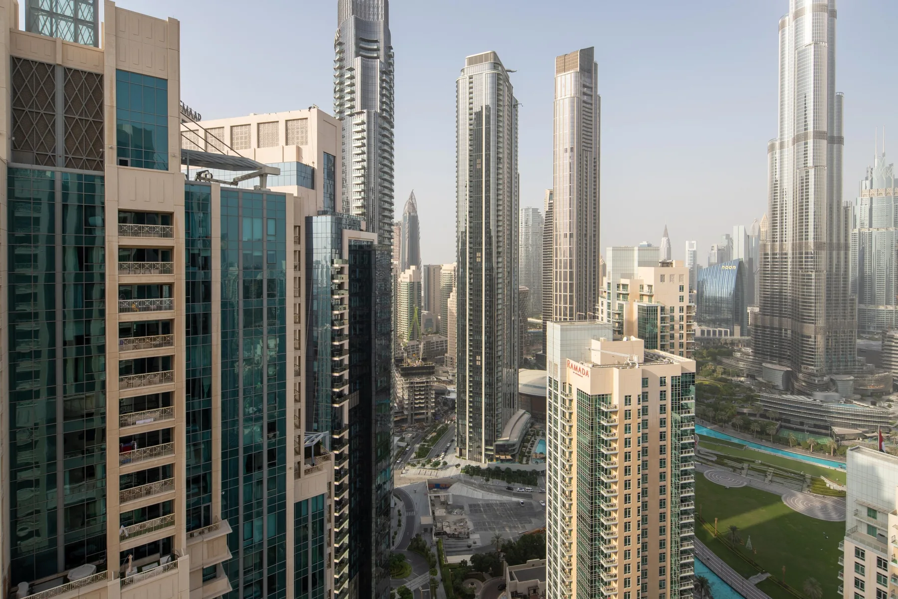 City skyline with tall modern buildings and a landscaped area in the foreground.