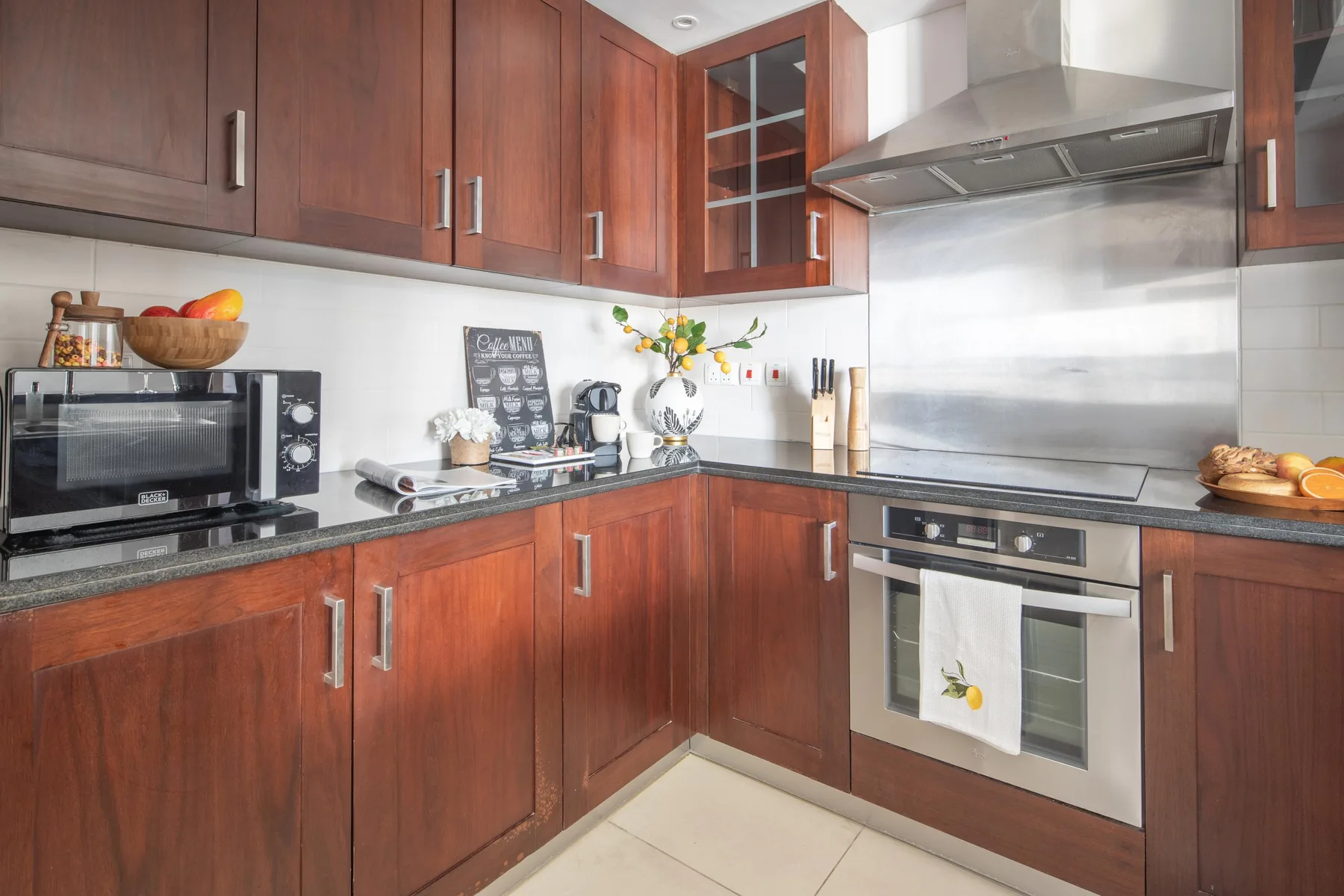 A bright kitchen with wooden cabinets, a countertop, and cooking appliances.