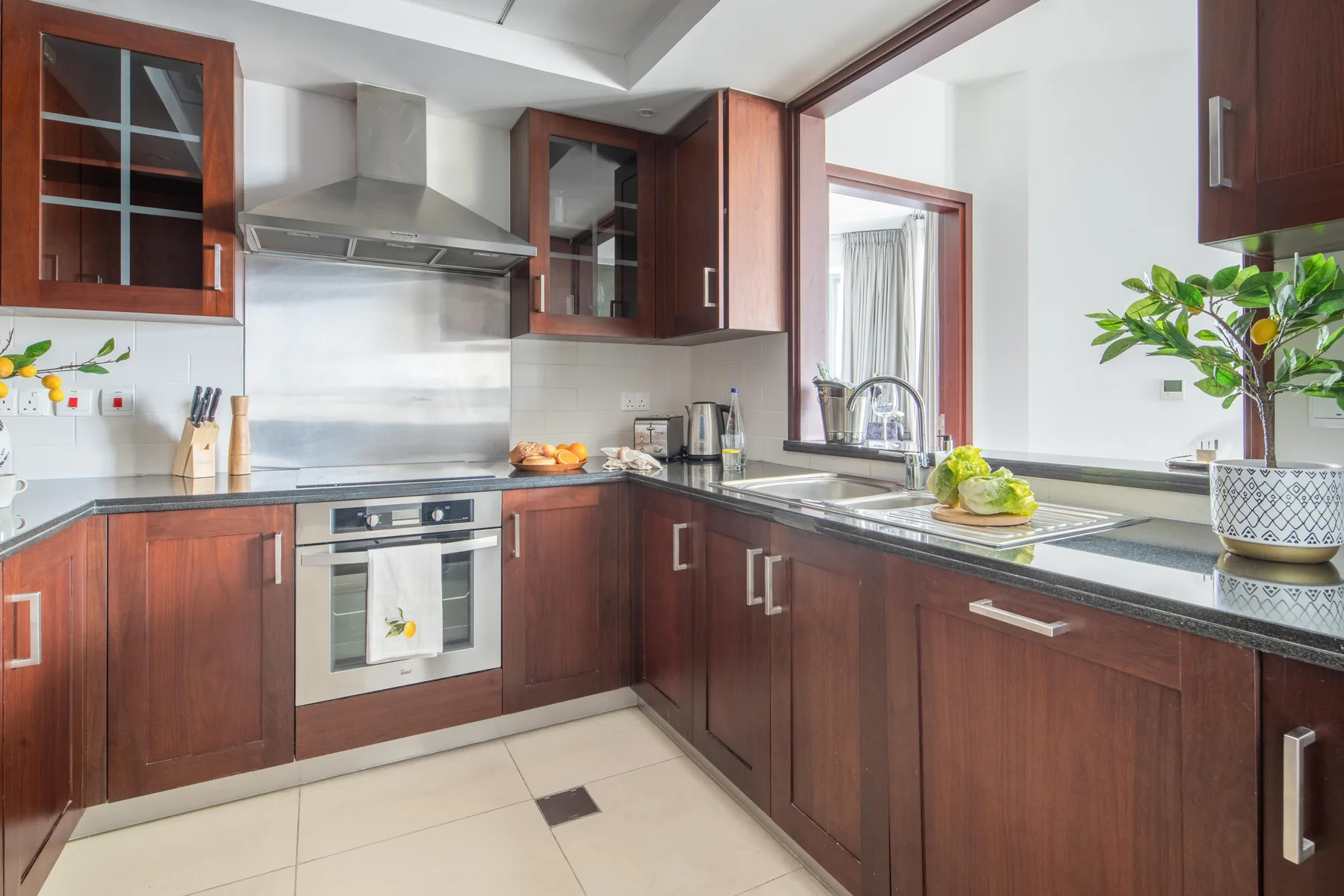 A kitchen with dark wood cabinets, a countertop, and a built-in oven.
