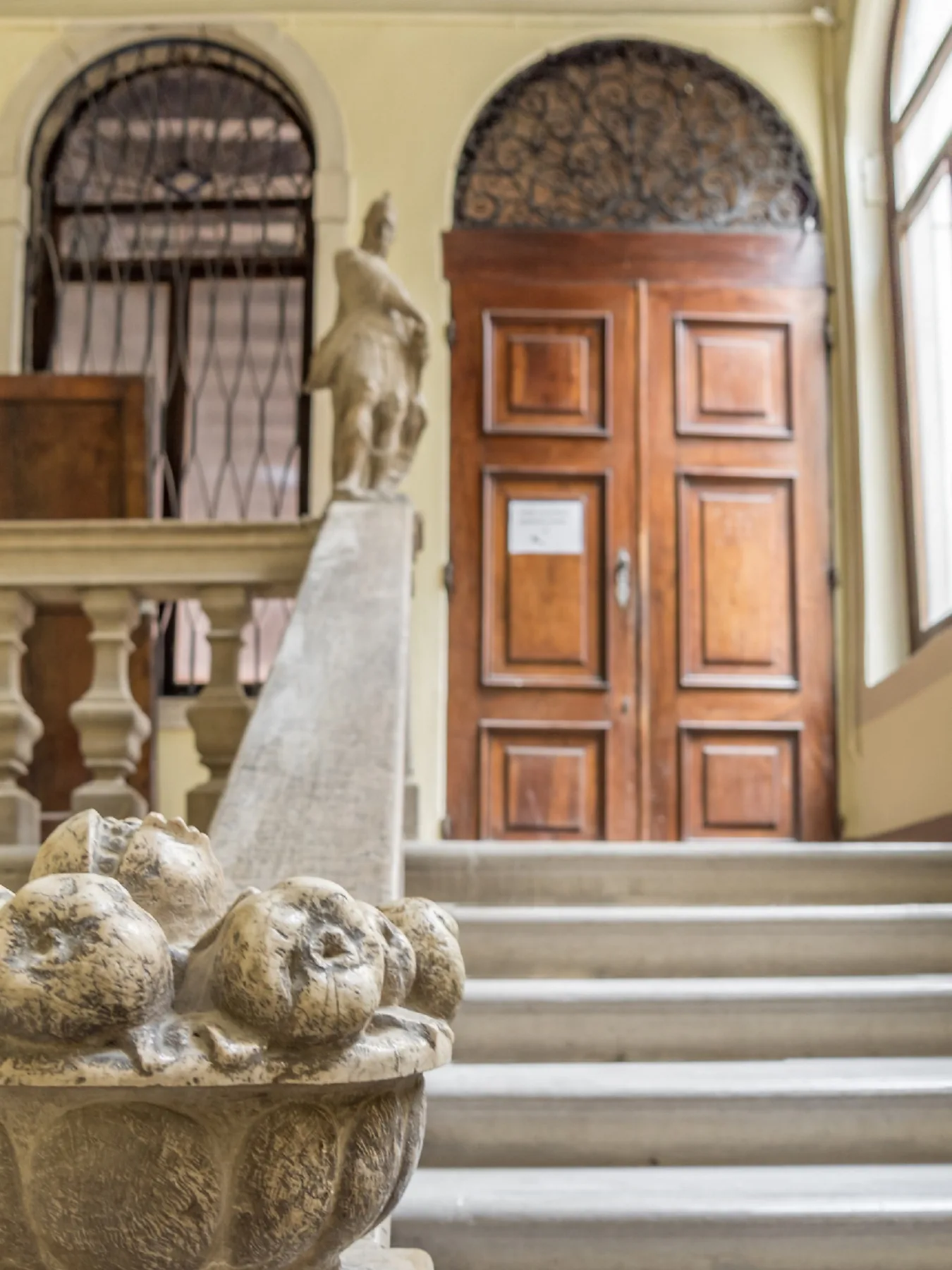Una entrada interior con una puerta de madera, escalones de piedra y una pila de piedra tallada.