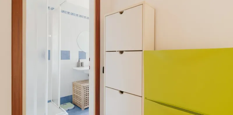 A bright bathroom with a glass shower and white storage cabinets.