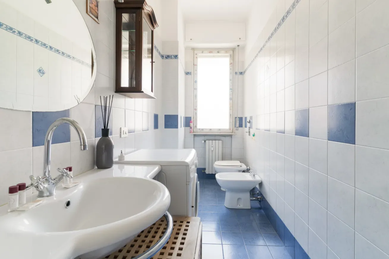 A tiled bathroom with a sink, toilet, and bathtub.