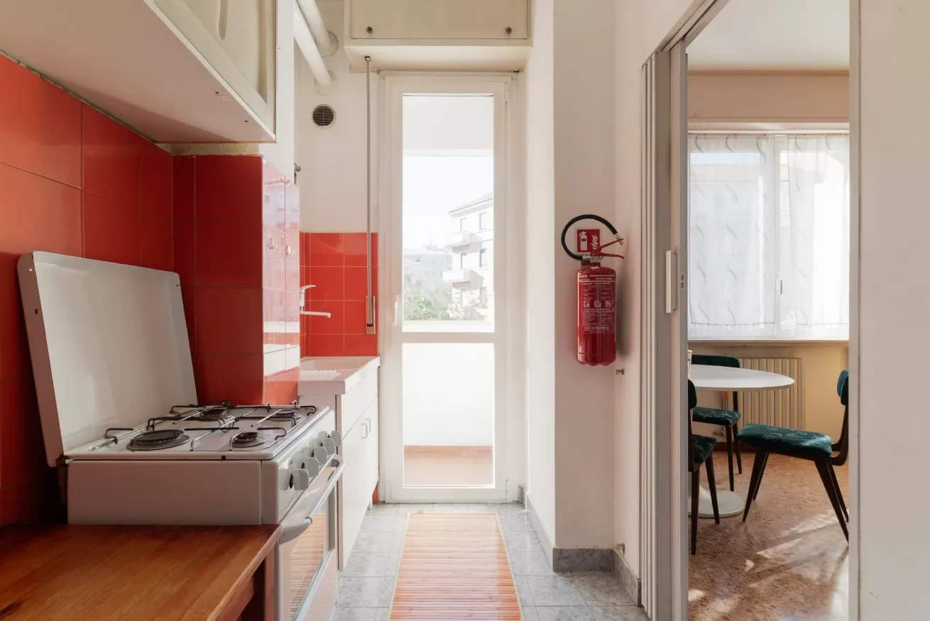 A kitchen with a gas cooktop beside a bright doorway.