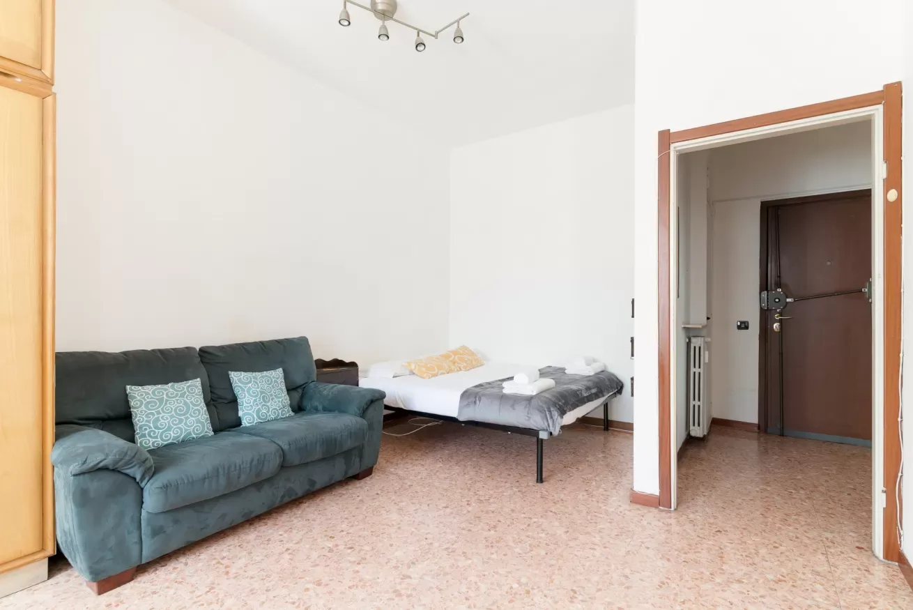 A living area with a sofa and a single bed.