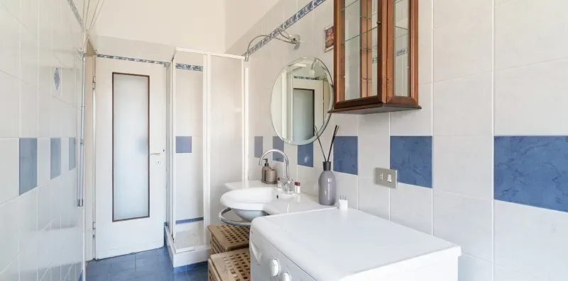A tiled bathroom with a bathtub, sink, and mirrored cabinet.