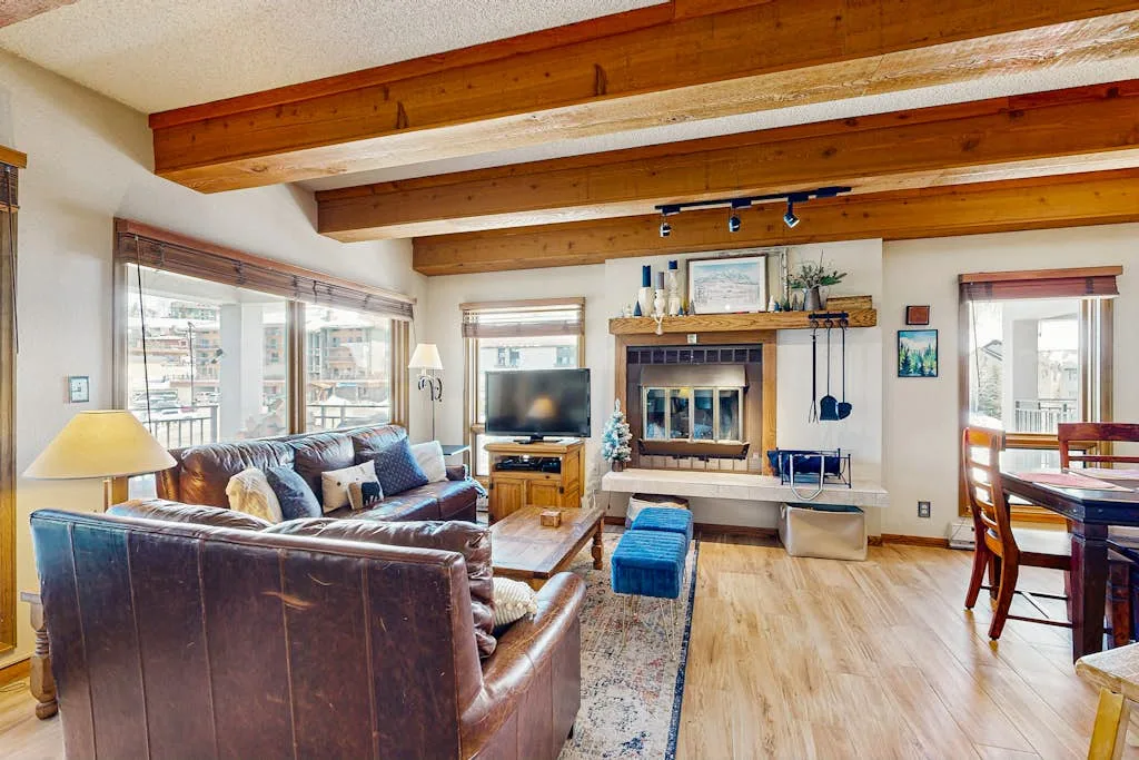 Living room with seating arranged around a fireplace and television.