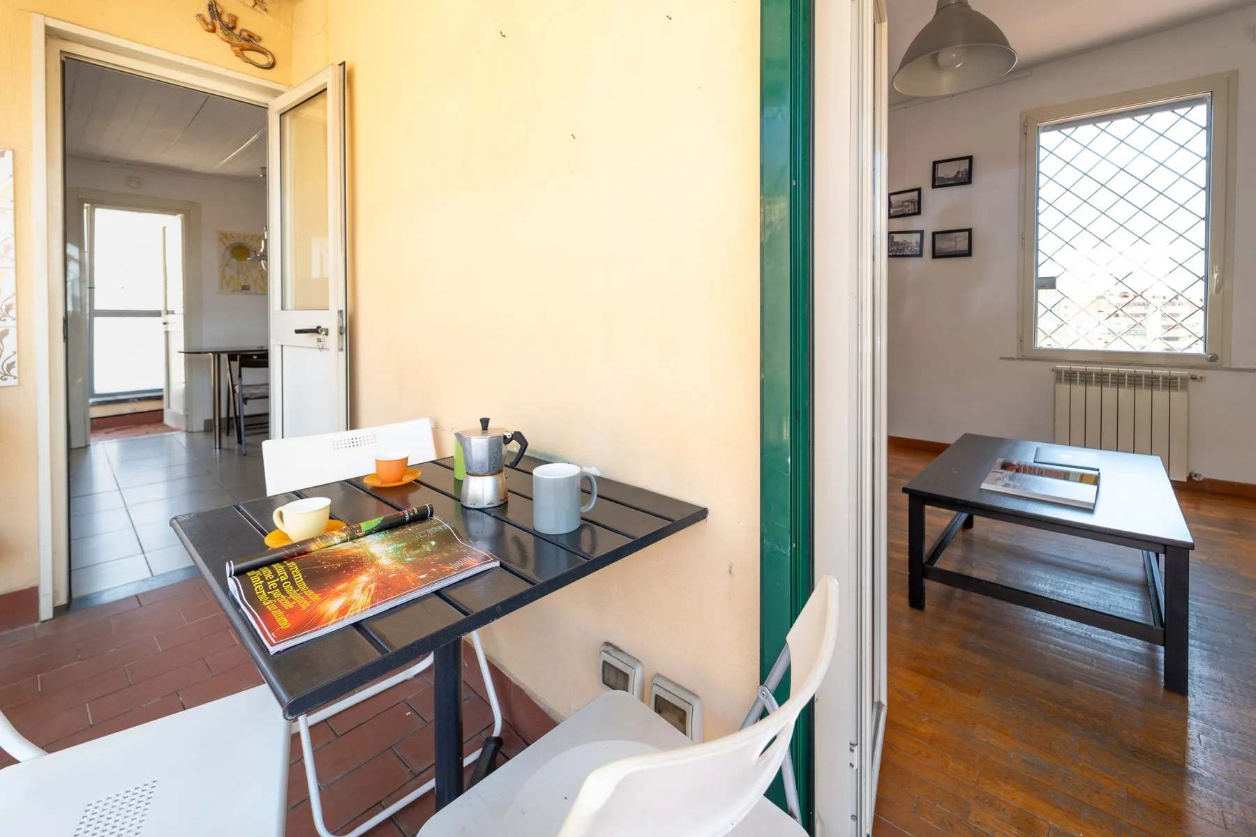 Una pequeña zona de comedor con una mesa puesta con tazas y una cafetera.