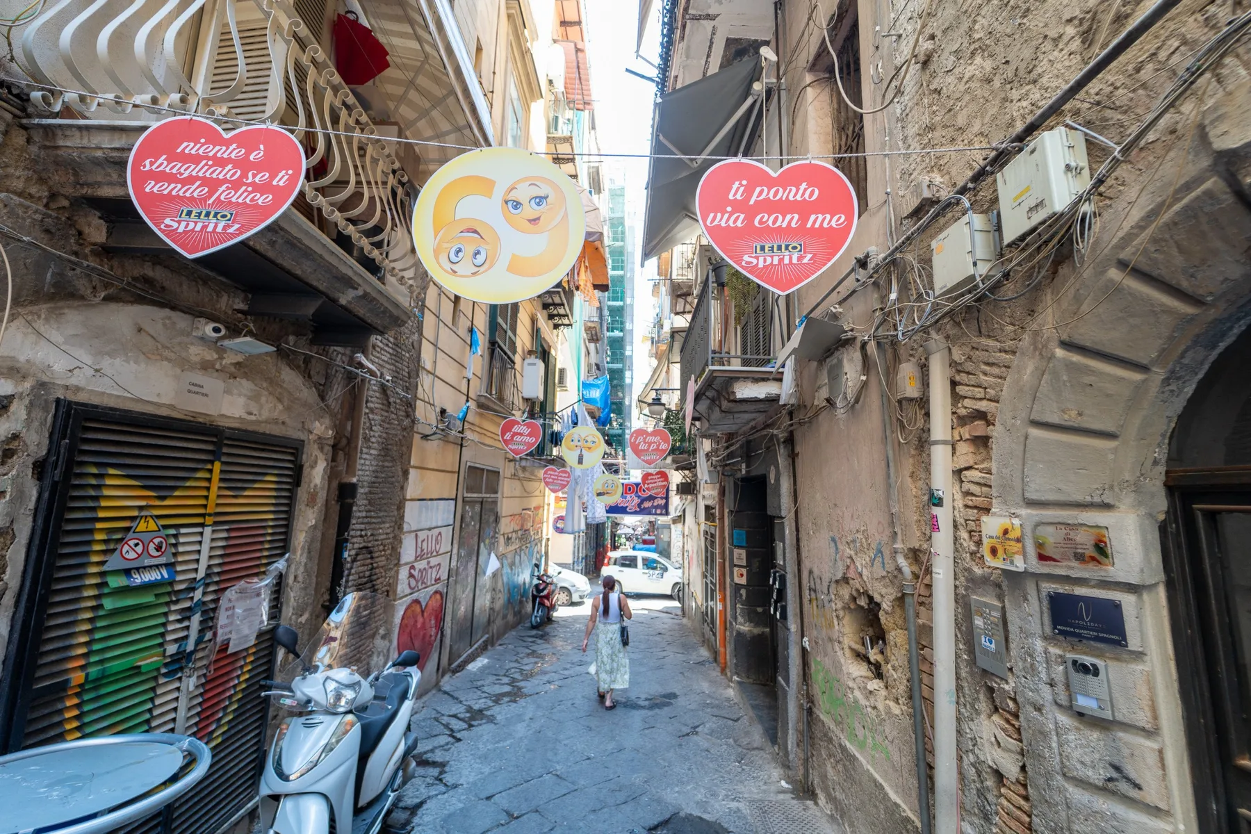 Un callejón estrecho de la ciudad, rodeado de edificios antiguos y letreros coloridos.