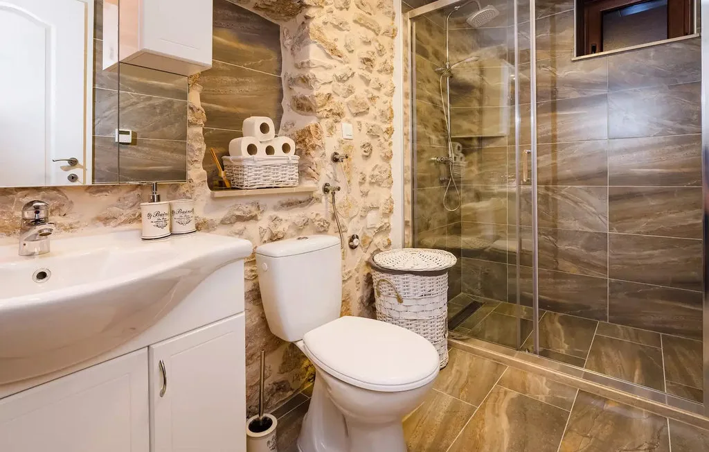 A bathroom with a sink, toilet, and glass shower.