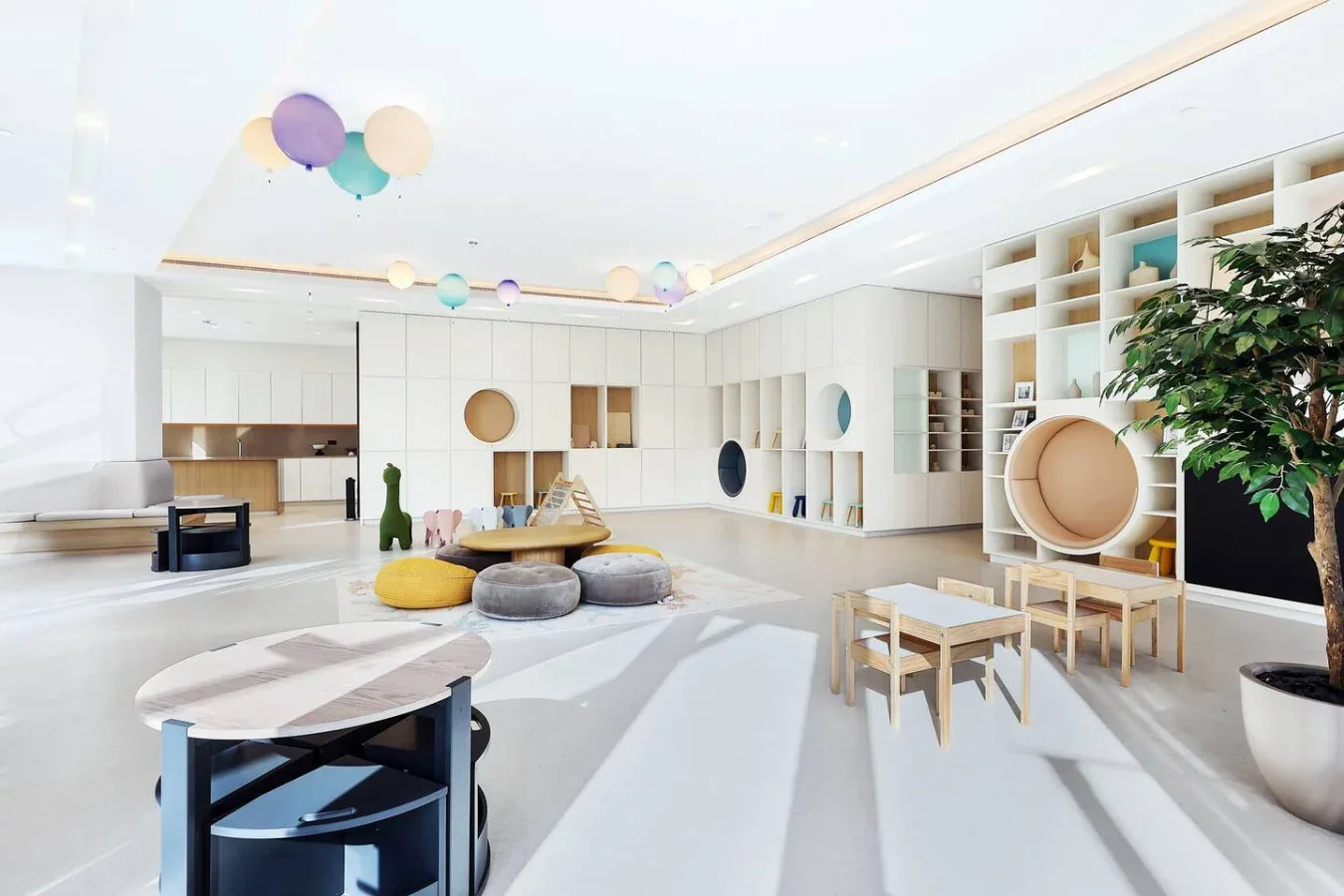 Una luminosa sala de juegos con globos de colores y asientos bajos.