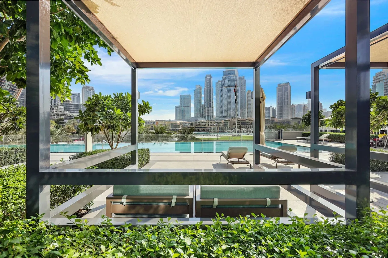 Una zona exterior cubierta con asientos da a una piscina y al horizonte de la ciudad.