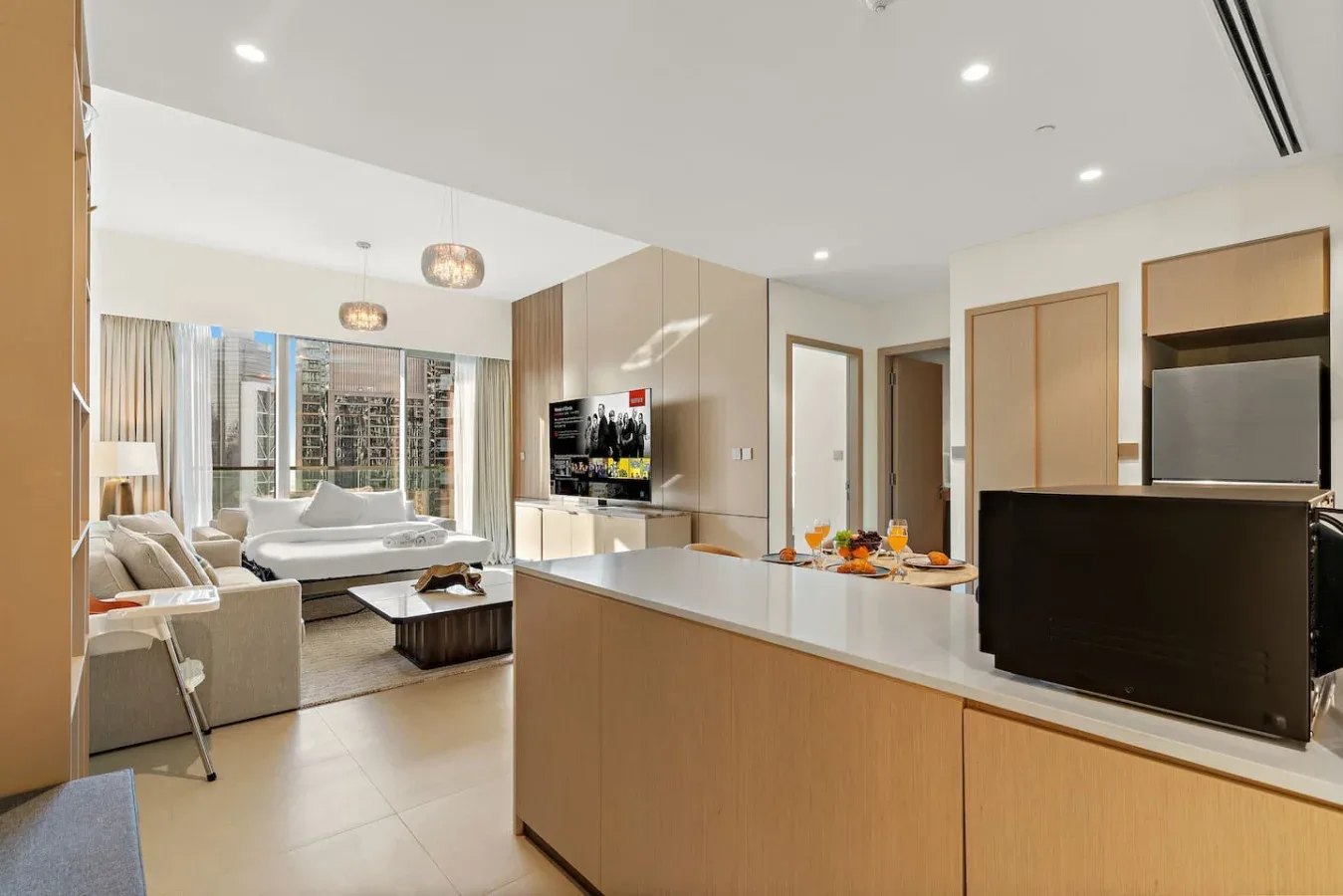 Sala de estar y cocina de concepto abierto, con televisor y barra de comedor.