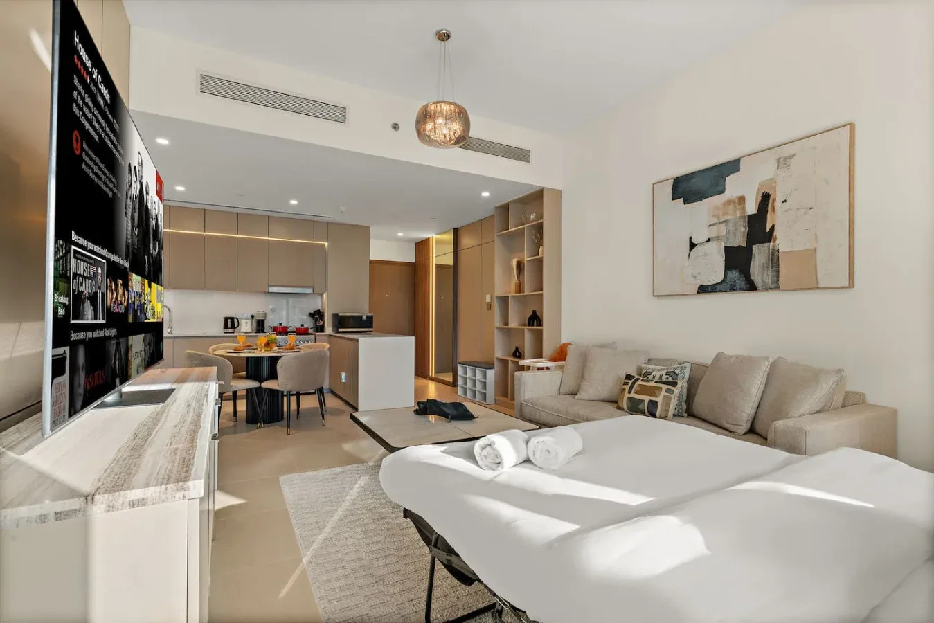 Una sala luminosa con comedor y cocina abierta.