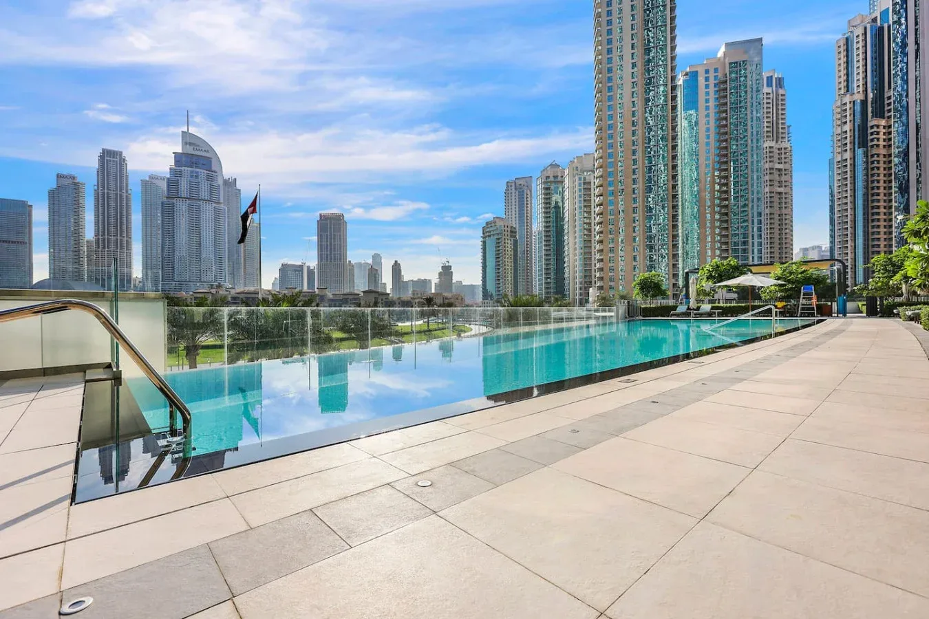 Una piscina en la azotea y una terraza pavimentada tienen vistas a edificios altos.