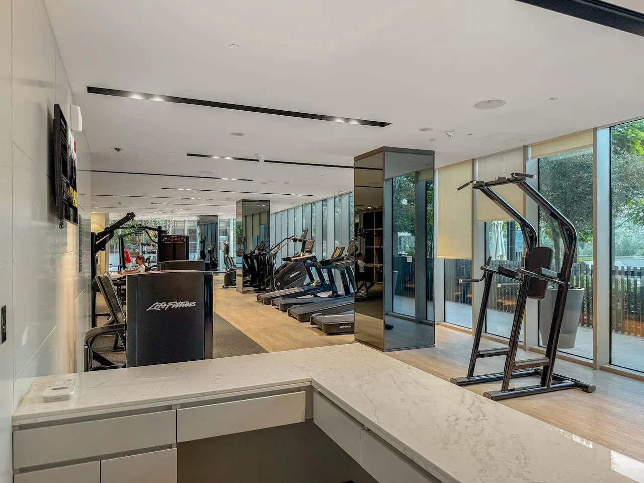 Una luminosa sala de entrenamiento con máquinas de ejercicio junto a ventanales.