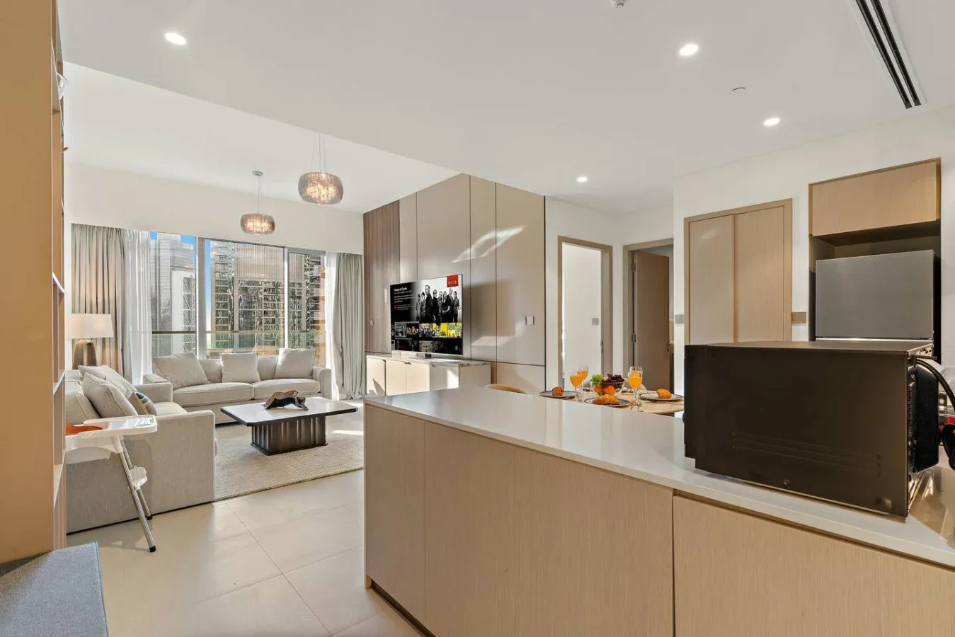 Sala de estar y cocina de planta abierta, con barra de comedor y asientos.