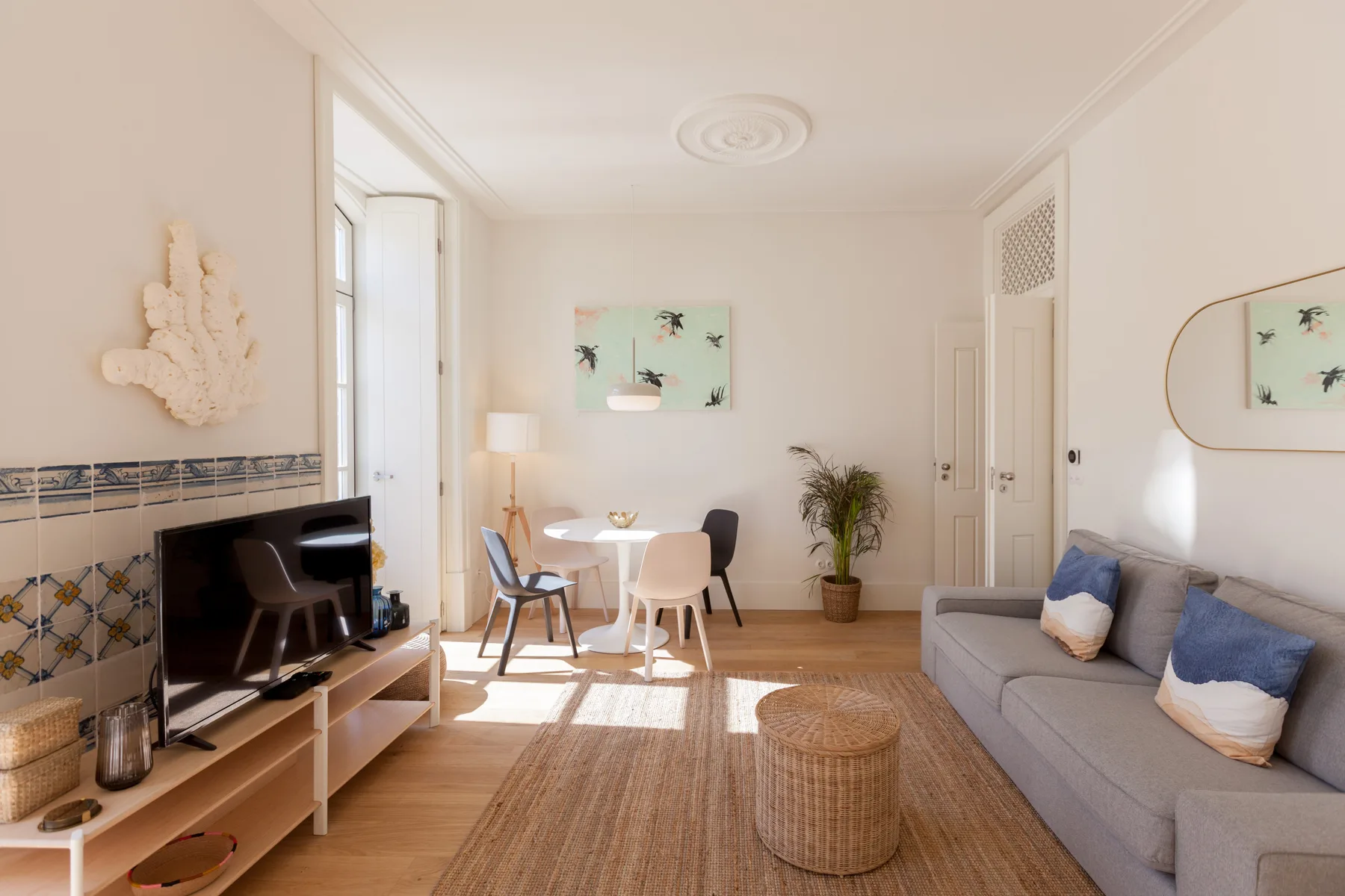 Una luminosa sala de estar con asientos, un televisor y un comedor.