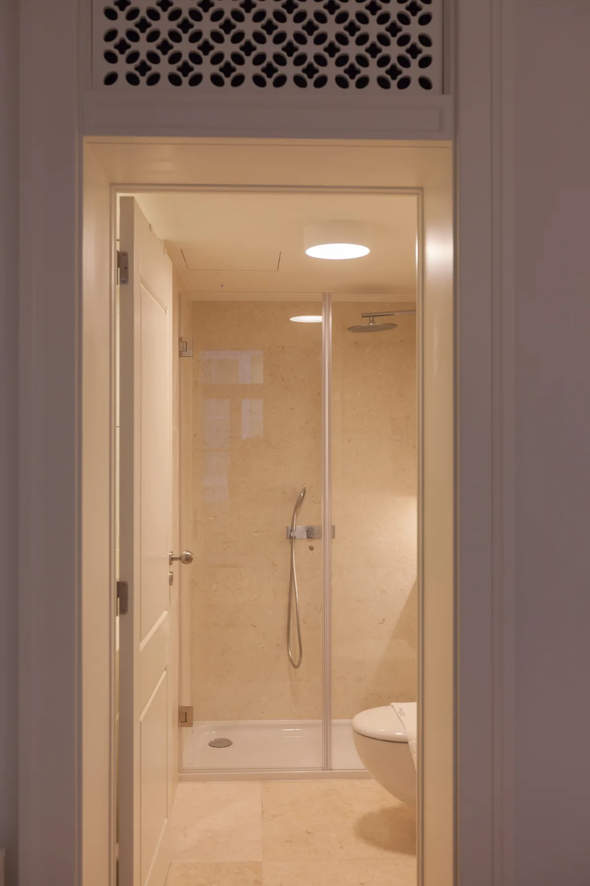 Un baño con una ducha de vidrio y un inodoro parcialmente visible.