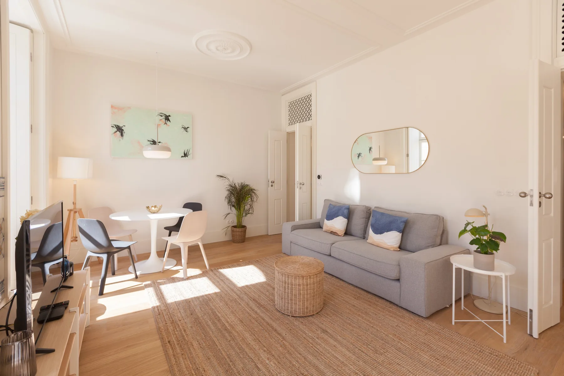 Una sala luminosa con asientos, una mesa de comedor y una alfombra tejida.