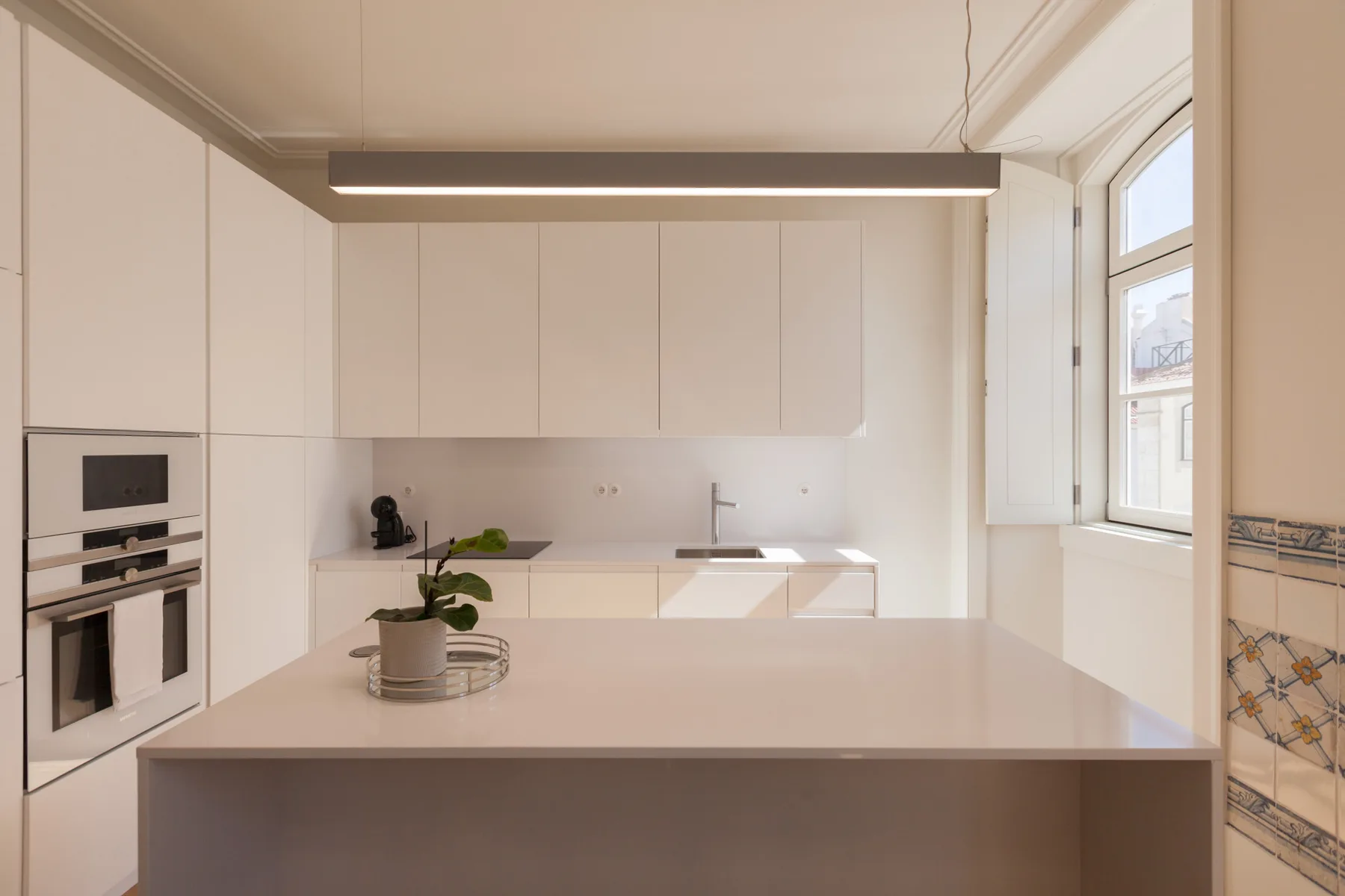 Una cocina moderna con una isla grande y electrodomésticos integrados.