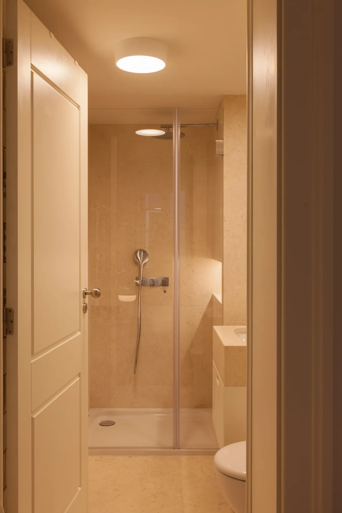 Un baño con una ducha de vidrio y un inodoro parcialmente visible.