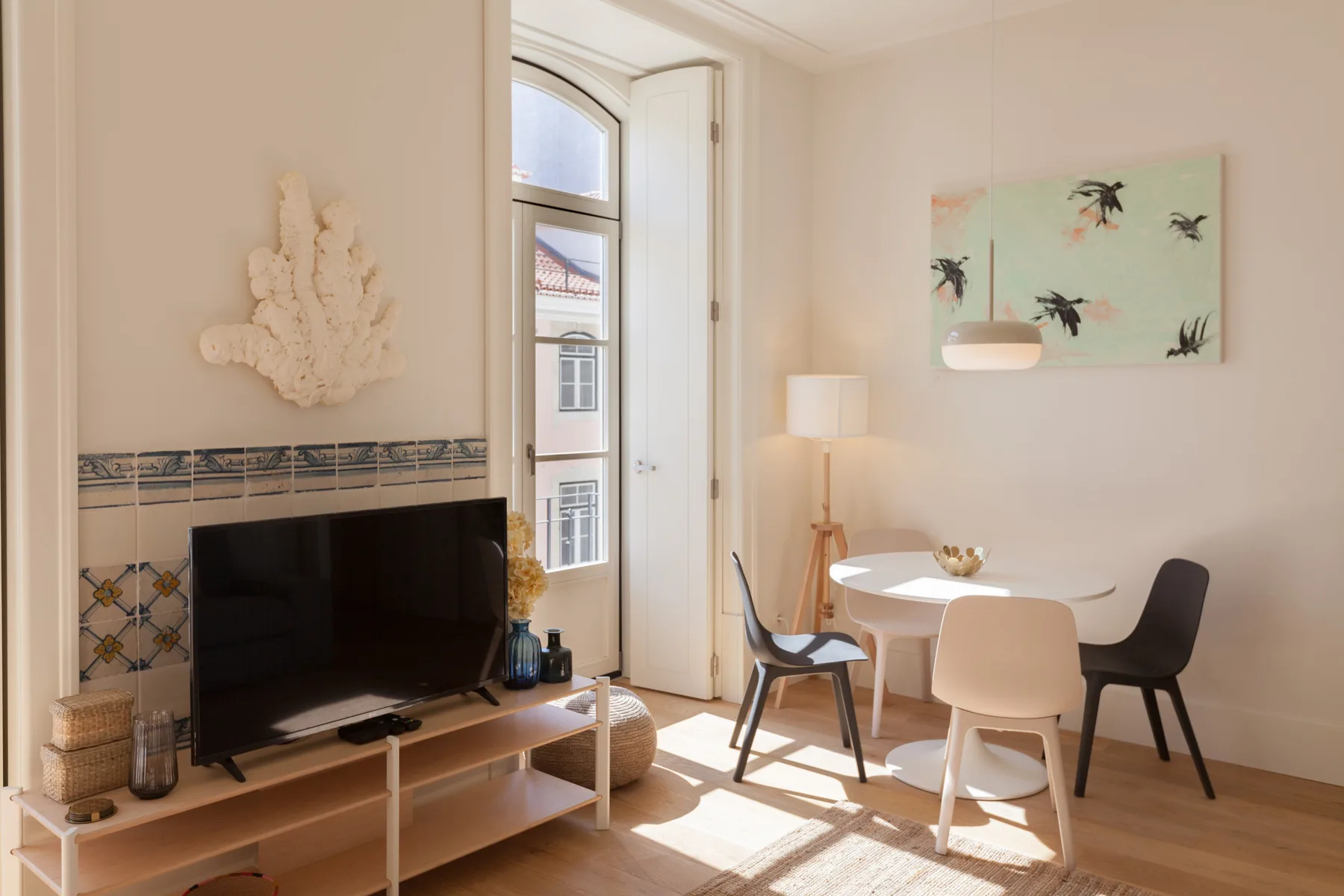 Una luminosa sala de estar y comedor con televisión, mesa y sillas.