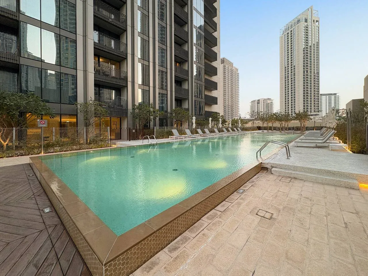 Una piscina al aire libre junto a modernos edificios altos.