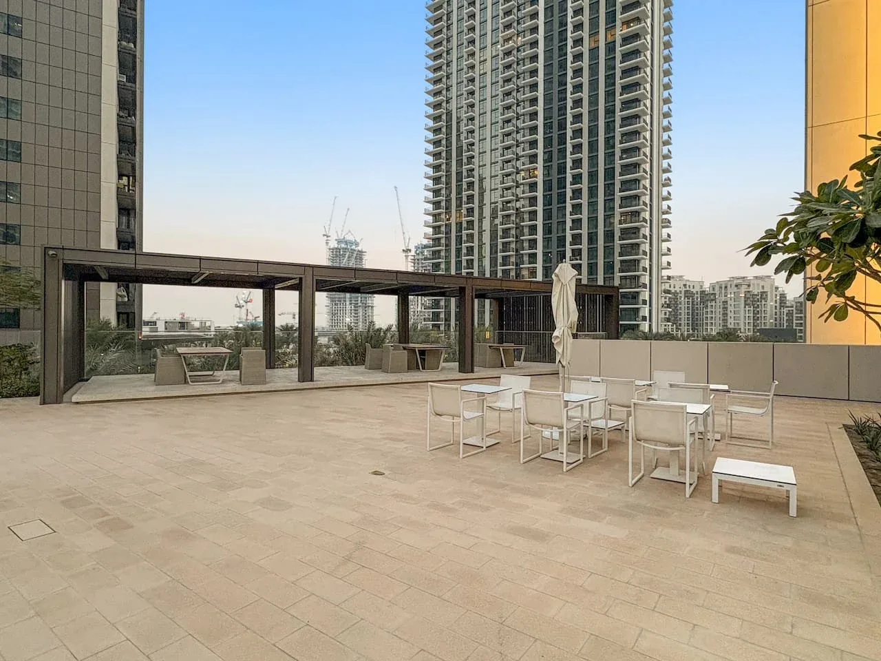 Una terraza en la azotea con asientos al aire libre y edificios altos al fondo.