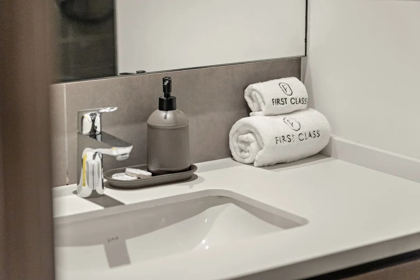 Un lavabo de baño con grifo y toallas dobladas cuidadosamente.