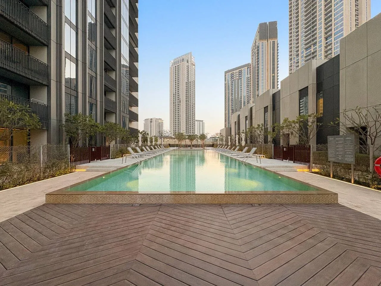 Una piscina al aire libre se encuentra entre modernos edificios altos.