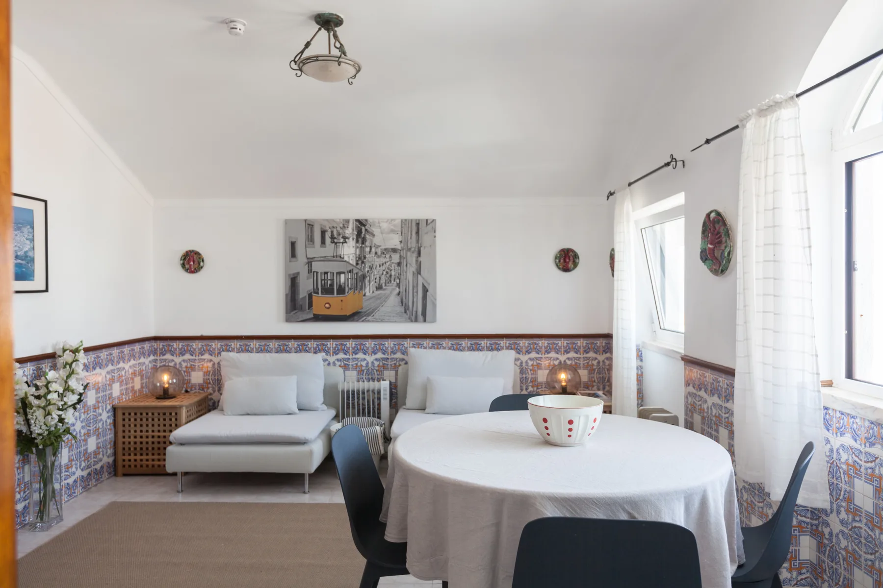 A dining and sitting area with a round table beside a sofa.
