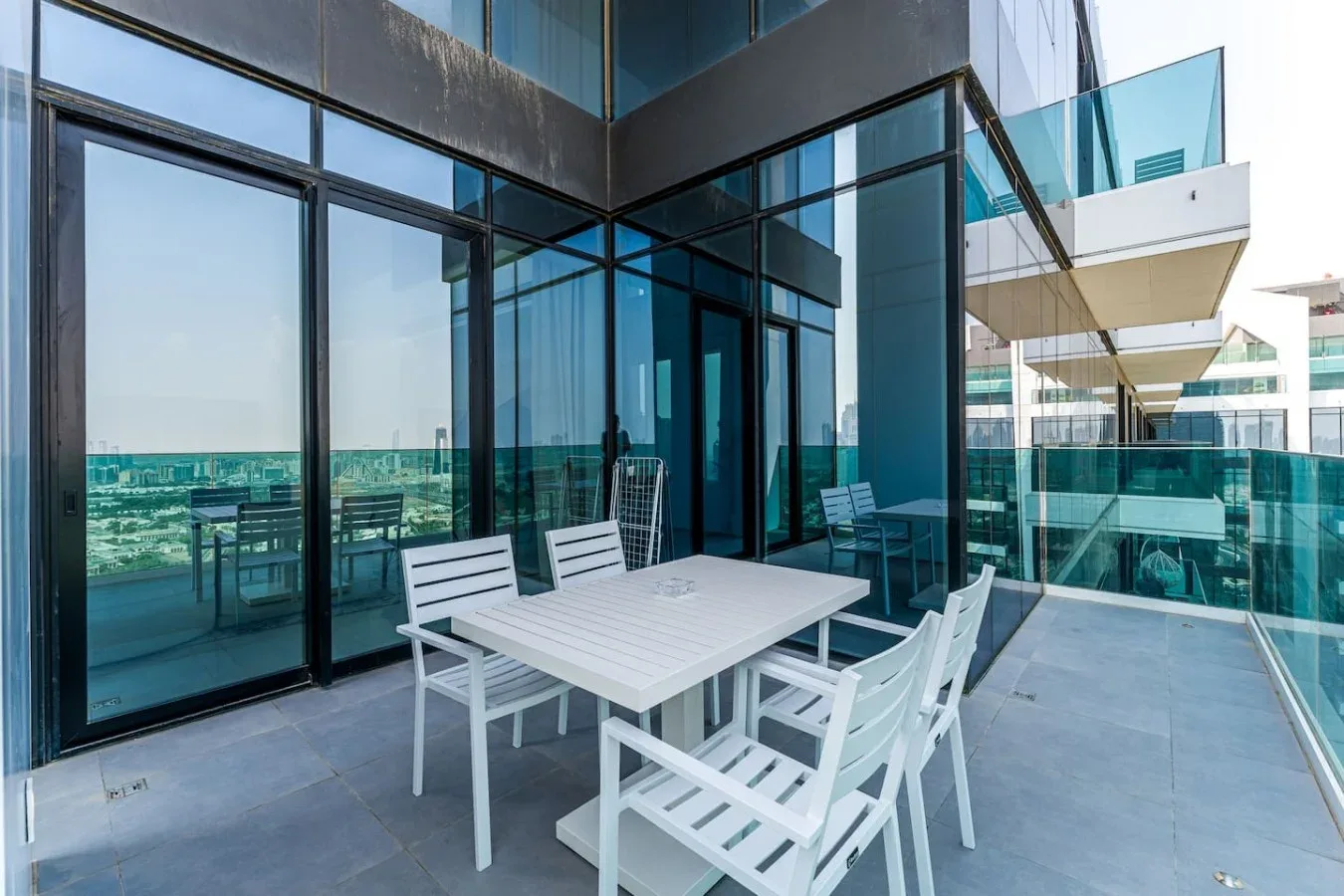 A glass-walled terrace with outdoor seating and a table.