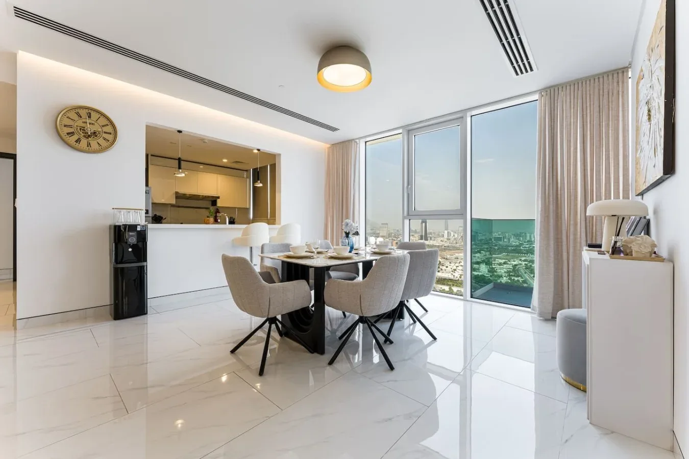 A bright dining area with a table beside floor-to-ceiling windows.