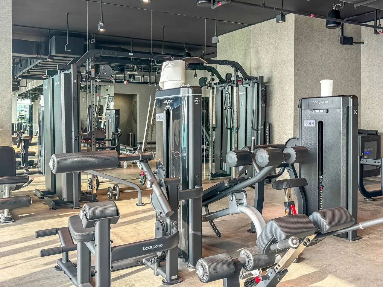 A gym with weight machines and exercise equipment arranged across the room.