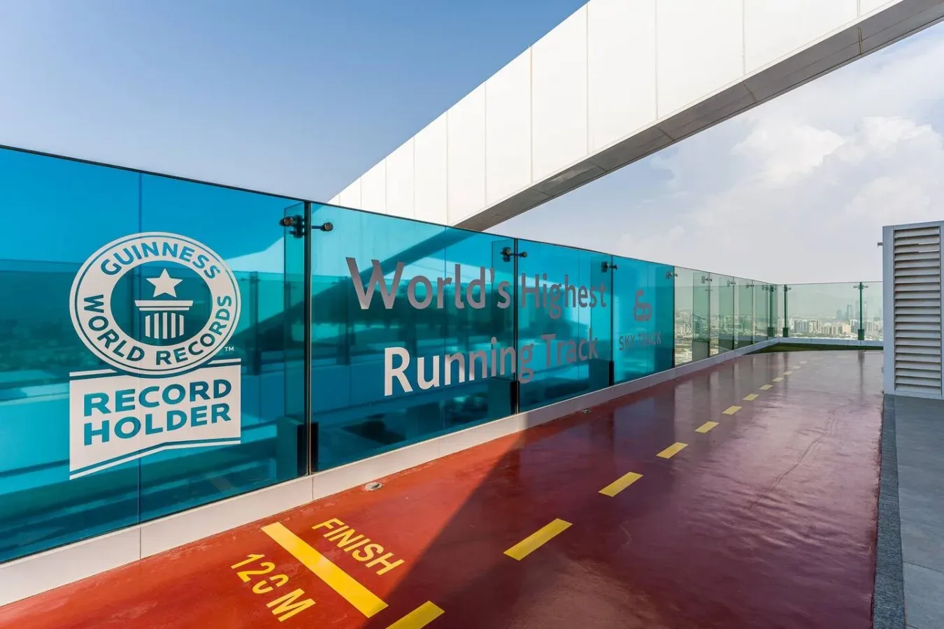 A rooftop running track with a Guinness World Records sign along the glass railing.