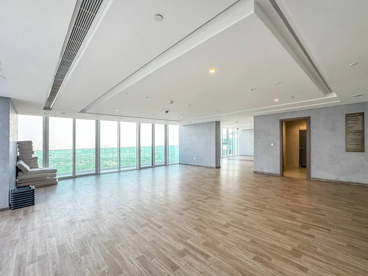 A bright open room has wide windows overlooking the water.