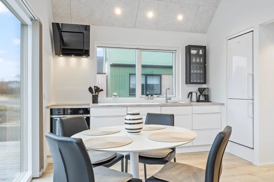 Una cocina luminosa con una mesa de comedor junto a la encimera.